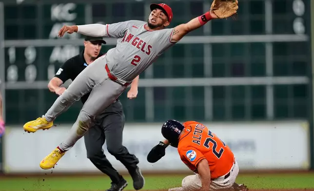 Houston Astros' Jose Altuve (27) steals second base ahead of a throw to Los Angeles Angels second baseman Oswald Peraza (2) during the fifth inning of a baseball game in Houston, Friday, March 27, 2026. (AP Photo/Ashley Landis)