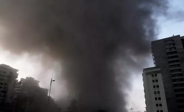 Smoke rises from a building targeted by an Israeli strike in central Beirut, Lebanon, Thursday, March 12, 2026. (AP Photo/Bilal Hussein)
