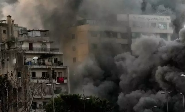 Smoke rises from a building hit by a targeted Israeli strike in central Beirut, Lebanon, Thursday, March 12, 2026. (AP Photo/Hussein Malla)