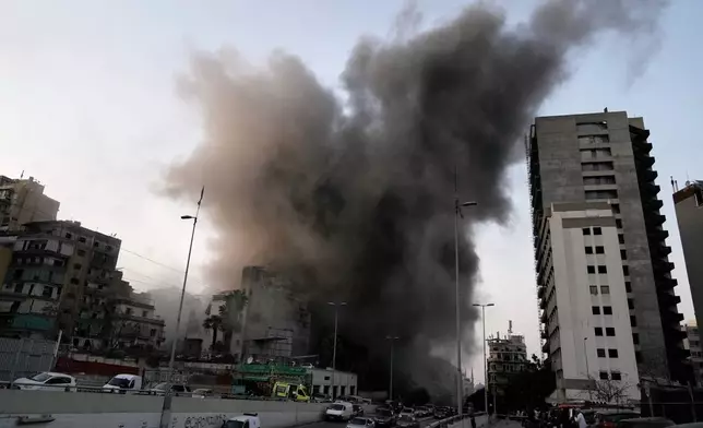 Smoke rises from a building targeted by an Israeli strike in central Beirut, Lebanon, Thursday, March 12, 2026. (AP Photo/Bilal Hussein)