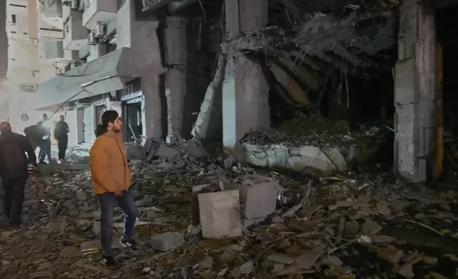 A man views the destroyed branch of Al-Qard Al-Hassan, a non-bank financial institution run by Hezbollah, that was hit by an Israeli airstrike in central Beirut, Lebanon, Thursday, March 12, 2026. (AP Photo/Hussein Malla)