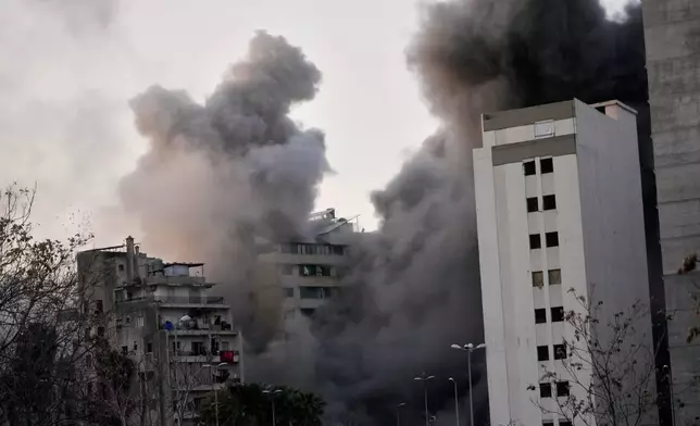 Smoke rises from a building after an Israeli strike in central Beirut, Lebanon, Thursday, March 12, 2026. (AP Photo/Hussein Malla)