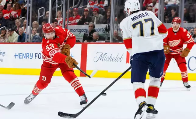 Detroit Red Wings defenseman Moritz Seider (53) shoots on goal against Florida Panthers defenseman Niko Mikkola (77) during the first period of an NHL hockey game Friday, March 6, 2026, in Detroit. (AP Photo/Duane Burleson)
