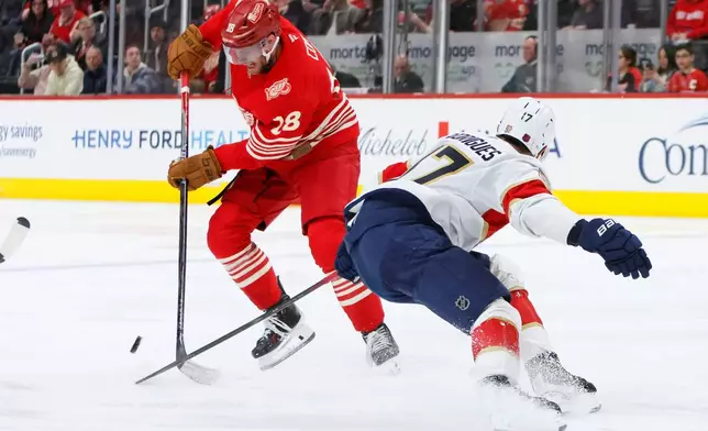 Detroit Red Wings center Andrew Copp (18) avoids Florida Panthers center Evan Rodrigues (17) to move the puck during the second period of an NHL hockey game Friday, March 6, 2026, in Detroit. (AP Photo/Duane Burleson)