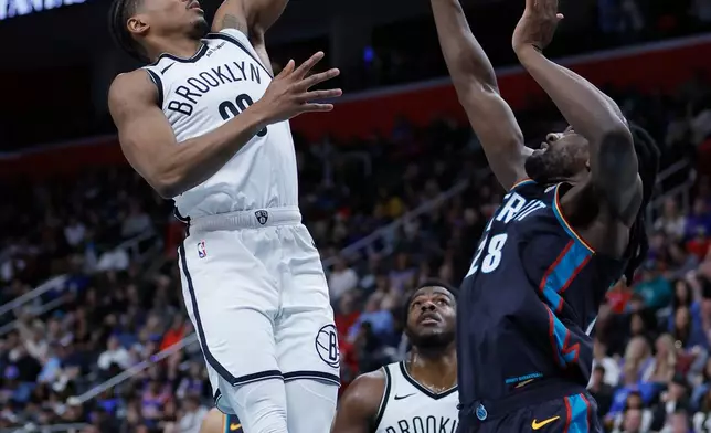 Brooklyn Nets guard Ochai Agbaji, left, goes in for a layup against Detroit Pistons forward Isaiah Stewart, right, during the first half of an NBA basketball game Saturday, March 7, 2026, in Detroit. (AP Photo/Duane Burleson)