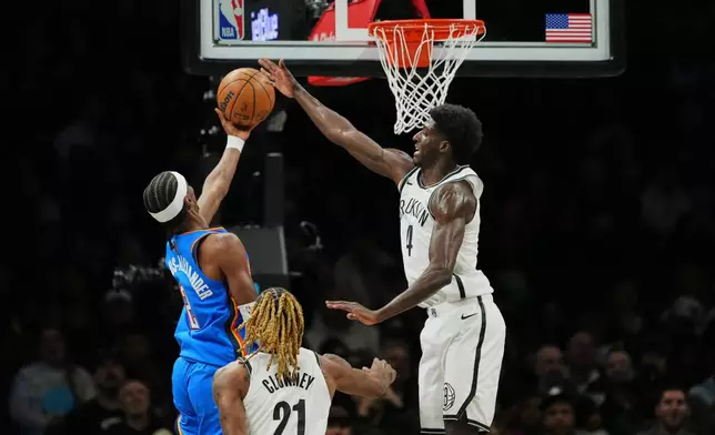Brooklyn Nets' Drake Powell (4) defends a shot by Oklahoma City Thunder's Shai Gilgeous-Alexander (2) during the first half of an NBA basketball game Wednesday, March 18, 2026, in New York. (AP Photo/Frank Franklin II)