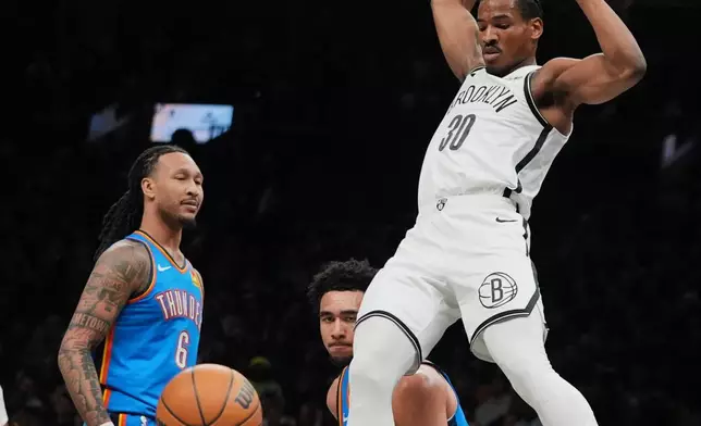 Brooklyn Nets' Ochai Agbaji (30) dunks the ball in front of Oklahoma City Thunder's Jaylin Williams (6) during the first half of an NBA basketball game Wednesday, March 18, 2026, in New York. (AP Photo/Frank Franklin II)