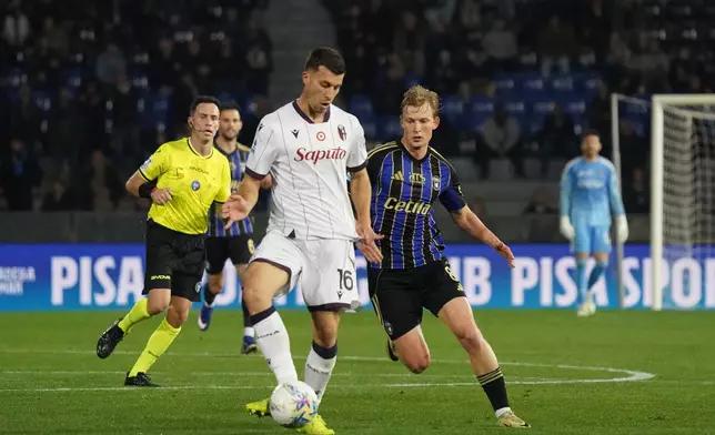 Bologna's Nicolo Casale and Pisa's Malthe Hojholt, right, go for the ball during the Serie A soccer match between Pisa and Bologna, in Pisa, Italy, Monday, March 2, 2026. (Alessandro La Rocca/LaPresse via AP)