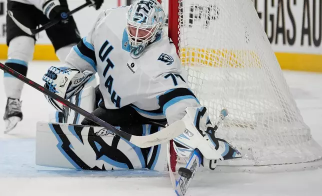 Utah Mammoth goaltender Karel Vejmelka (70) knocks the puck away against the Vegas Golden Knights during the second period of an NHL hockey game Thursday, March 19, 2026, in Las Vegas. (AP Photo/John Locher)