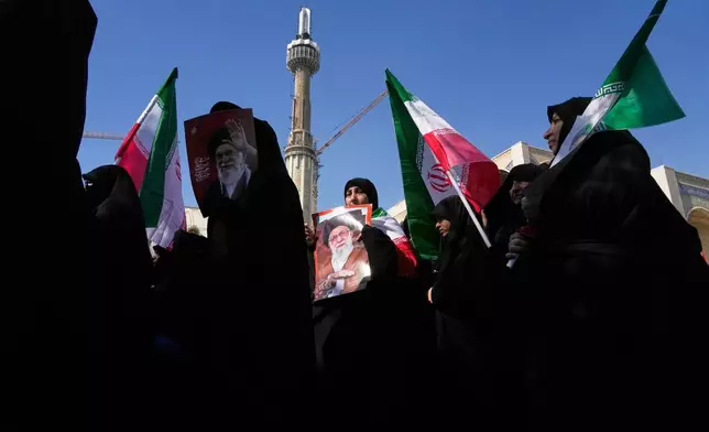 Women hold Iranian flags and pictures of the late Iranian Supreme Leader Ali Khamenei as government supporters march against the ongoing U.S.-Israeli military campaign after Friday prayers at the Imam Khomeini Grand mosque in Tehran, Iran, Friday, March 6, 2026. (AP Photo/Vahid Salemi)
