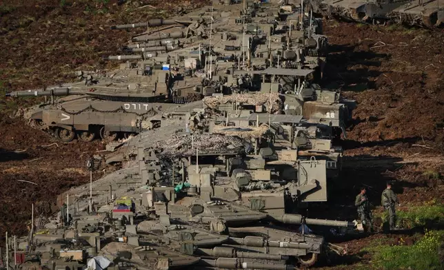 Israeli soldiers work on tanks at a staging area in northern Israel near the border with Lebanon, Friday, March 6, 2026. (AP Photo/Ariel Schalit)
