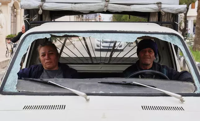 A man and a woman drive a vehicle with a shattered windshield in the predominantly Christian town of Al-Suqaylabiyah, west of Hama, Syria, Saturday, March 28, 2026, following overnight violence. (AP Photo/Omar Albam)
