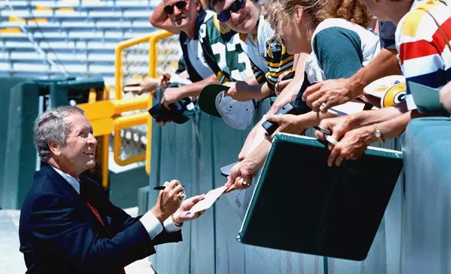 FILE - Green Bay Packers President Bob Harlan signs autographs after the Packers stock holders meeting at Lambeau Field, July 7, 1999, in Green Bay, Wis. (AP Photo/Mike Roemer, File)