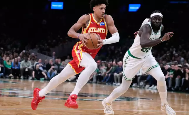 Atlanta Hawks forward Jalen Johnson drives to the basket against Boston Celtics center Neemias Queta during the second half of an NBA basketball game, Friday, March 27, 2026, in Boston. (AP Photo/Charles Krupa)