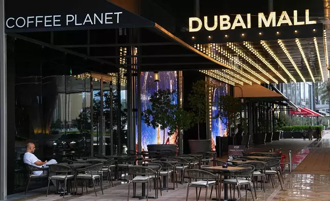 A man sits at an outdoor empty cafe in downtown Dubai, United Arab Emirates, Saturday, March 7, 2026. (AP Photo/Fatima Shbair)