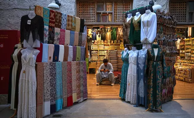 A vendor sits inside a shop at the empty Al Seef market, next to the historic Al Fahidi neighborhood along Dubai Creek, one of the main tourist areas of Dubai, United Arab Emirates, Friday, March 13, 2026, as tourism slows amid regional tensions linked to the Iran war. (AP Photo/Fatima Shbair)