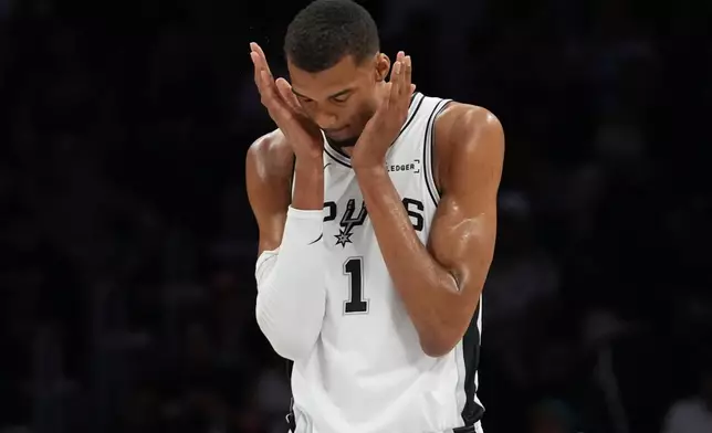 San Antonio Spurs forward Victor Wembanyama (1) walks on the court during the first half of an NBA basketball game against the Miami Heat, Monday, March 23, 2026, in Miami. (AP Photo/Lynne Sladky)