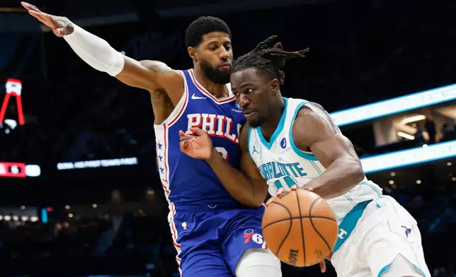 Charlotte Hornets guard Sion James, right, drives the baseline against Philadelphia 76ers forward Paul George during the first half of an NBA basketball game in Charlotte, N.C., Saturday, March 28, 2026. (AP Photo/Nell Redmond)