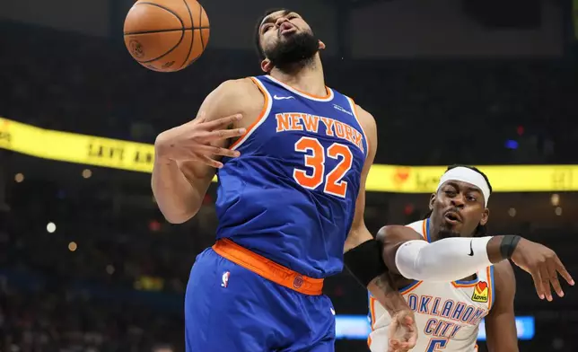 New York Knicks center Karl-Anthony Towns (32) loses control of the ball against Oklahoma City Thunder guard Luguentz Dort (5) during the first half of an NBA basketball game Sunday, March 29, 2026, in Oklahoma City. (AP Photo/Nate Billings)