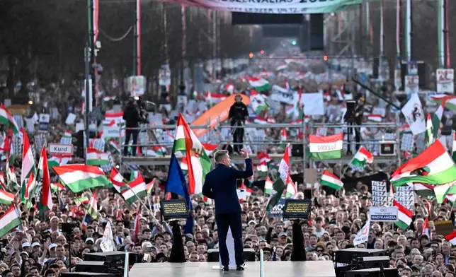 Opposition leader Peter Magyar, center, addresses his supporters during a march in Budapest, Sunday, March 15, 2026. (AP Photo/Denes Erdos)