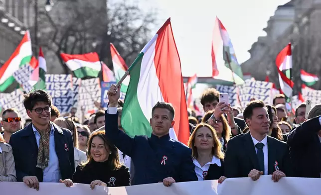 Opposition leader Peter Magyar, center, waves a flag during a march in Budapest, Hungary, Sunday, March 15, 2026. (AP Photo/Denes Erdos)