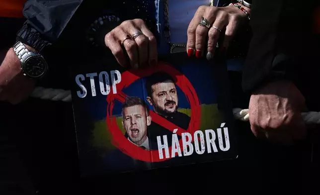A supporter of Prime Minister Viktor Orban holds a placard reading "Stop the War" during a march in Budapest, Hungary, Sunday, March 15, 2026. (AP Photo/Denes Erdos)