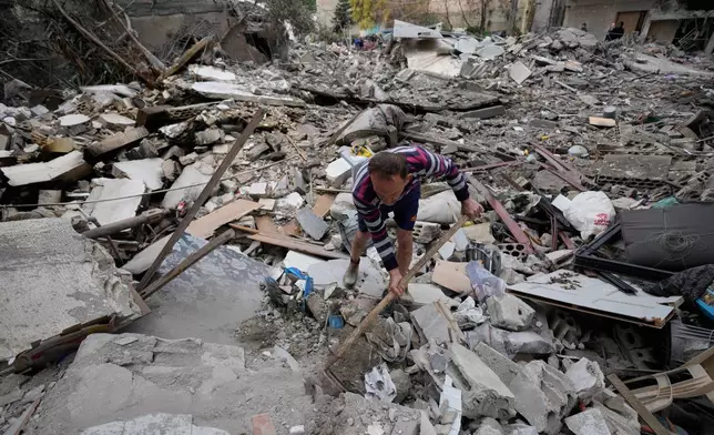 A man removes rubbles as he looks for missed stuff from his destroyed house that was hit in an Israeli airstrike in the southern port city of Tyre, Lebanon, Thursday, March 26, 2026. (AP Photo/Hussein Malla)