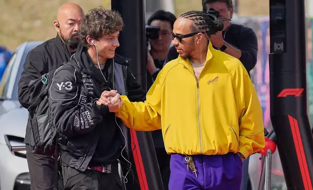 Mercedes driver Kimi Antonelli of Italy, left, and Ferrari driver Lewis Hamilton of Britain, right, greet each other prior to the Japanese Formula One Grand Prix Sunday, March 29, 2026, in Suzuka, central Japan. (AP Photo/Eugene Hoshiko)