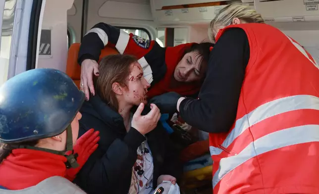 Paramedics give first aid to an injured resident following Russian aerial guided bomb strike in Zaporizhzhia, Ukraine, Saturday, March 14, 2026. (AP Photo/Kateryna Klochko)