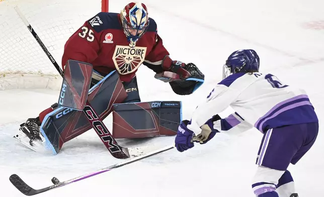 Minnesota Frost's Katy Knoll, right, moves in right Montreal Victoire goaltender Ann-Renee Desbiens (35) during second-period PWHL hockey game action in Laval, Quebec, Sunday, March 1, 2026. (Graham Hughes/The Canadian Press via AP)