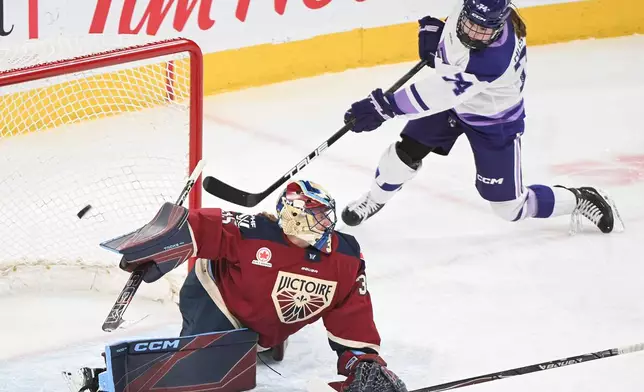 Minnesota Frost's Abby Hustler (74) shoots against Montreal Victoire goaltender Ann-Renee Desbiens, left, during second-period PWHL hockey game action in Laval, Quebec, Sunday, March 1, 2026. (Graham Hughes/The Canadian Press via AP)