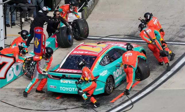Crew members perform a pit stop on driver Denny Hamlin's car during a NASCAR Cup Series auto race in Martinsville, Va., Sunday, March 29, 2026. (AP Photo/Chuck Burton)