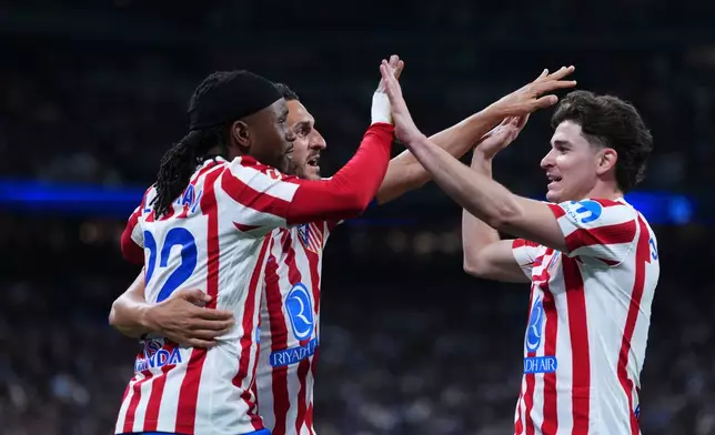 Atletico Madrid's Ademola Lookman, left, celebrates with Koke, centre, and Julian Alvarez after scoring the opening goal during the Spanish La Liga soccer match between Real Madrid and Atletico Madrid in Madrid, Spain, Sunday, March 22, 2026. (AP Photo/Manu Fernandez)