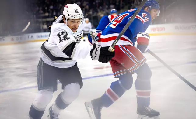 Los Angeles Kings left wing Trevor Moore (12) chases the puck during the second period of an NHL hockey game against the New York Rangers, Monday, March 16, 2026, in New York. (AP Photo/Angelina Katsanis)