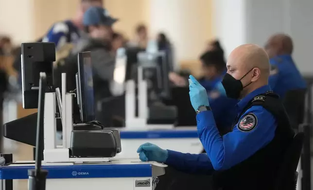 A Covenant Aviation Security Private Security Services agent checks the identifcation of a passenger at a security gate at San Francisco International Airport in San Francisco, Friday, Feb. 27, 2026. (AP Photo/Jeff Chiu)
