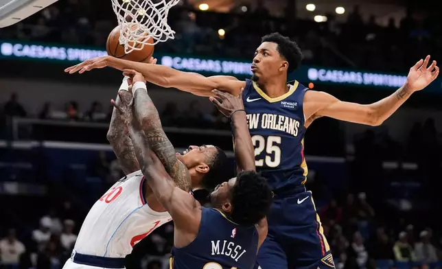 Los Angeles Clippers forward John Collins (20) is stopped driving to the basket against New Orleans Pelicans forward Trey Murphy III (25) and center Yves Missi (21) in the first half of an NBA basketball game, Wednesday, March 18, 2026, in New Orleans. (AP Photo/Gerald Herbert)