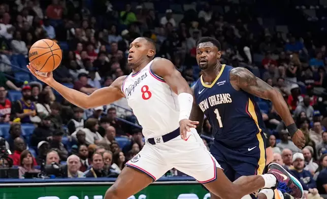 Los Angeles Clippers guard Kris Dunn (8) drives to the basket on a fast break against New Orleans Pelicans forward Zion Williamson (1) in the first half of an NBA basketball game, Wednesday, March 18, 2026, in New Orleans. (AP Photo/Gerald Herbert)