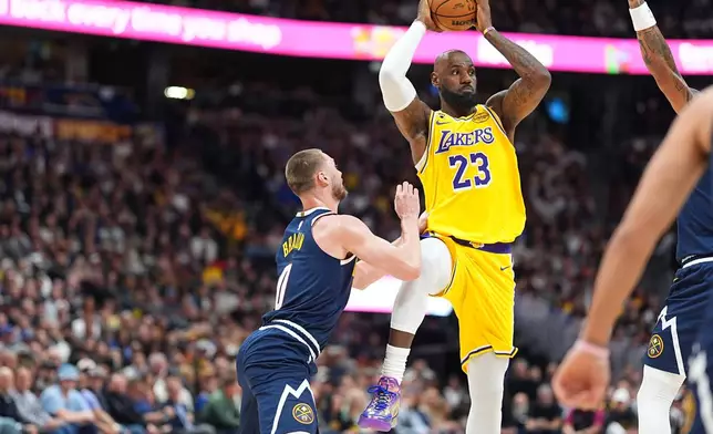 Los Angeles Lakers forward LeBron James, right, passes the ball as Denver Nuggets guard Christian Braun defends in the first half of an NBA basketball game, Thursday, March 5, 2026, in Denver. (AP Photo/David Zalubowski)