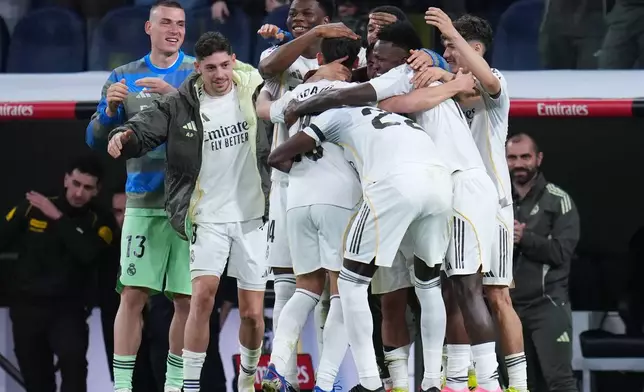 Real Madrid's Arda Guler, center, celebrates after scoring his side's fourth goal during a Spanish La Liga soccer match between Real Madrid and Elche CF, in Madrid, Saturday, March 14, 2026. (AP Photo/Manu Fernandez)