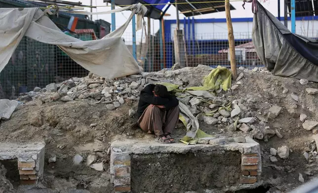 A man sits beside the site of a late-Monday airstrike at a drug rehabilitation hospital in Kabul, Afghanistan, Tuesday, March 17, 2026. (AP Photo/Siddiqullah Alizai)