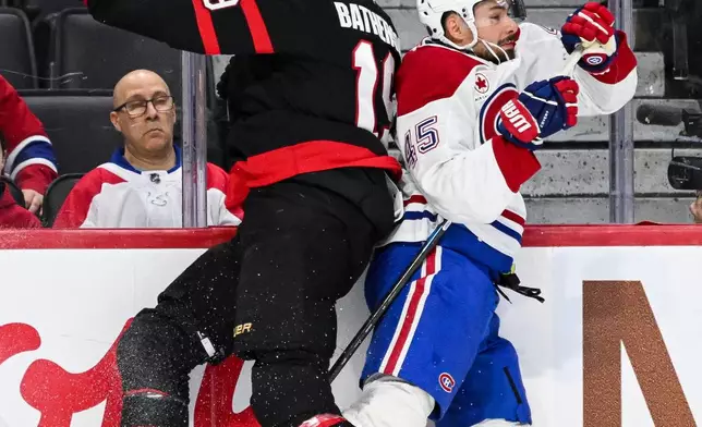 Ottawa Senators' Drake Batherson (19) checks Montreal Canadiens' Alexandre Carrier (45) along the boards during the first period of an NHL hockey game in Ottawa, Wednesday, March 11, 2026. (Spencer Colby/The Canadian Press via AP)