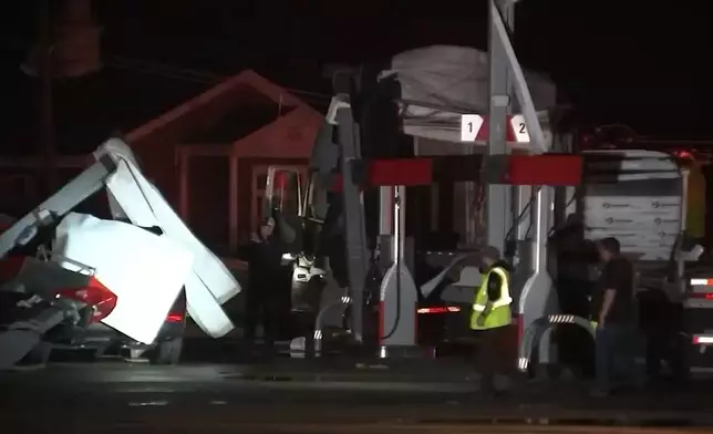 CORRECTS STATE TO INDIANA - Debris covers vehicles and damged a structure after a severe storm passed the area in in Lake Village, Ind., late Tuesday, March 10, 2026. (WLS-TV via AP)