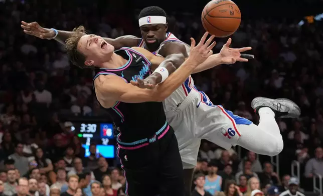 Miami Heat guard Pelle Larsson, left, is fouled by Philadelphia 76ers center Adem Bona, right, during the second half of an NBA basketball game, Monday, March 30, 2026, in Miami. (AP Photo/Lynne Sladky)
