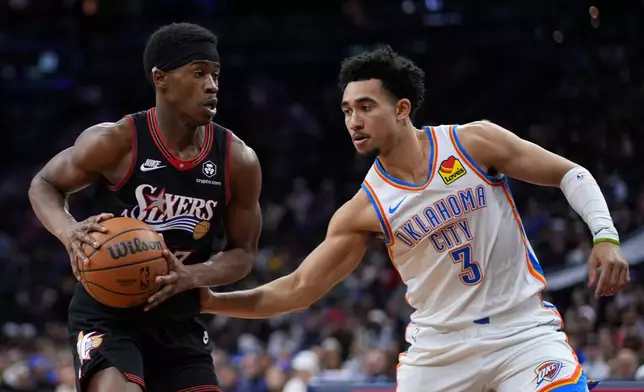 Philadelphia 76ers' Vj Edgecombe, left, tries to get past Oklahoma City Thunder's Jared McCain during the first half of an NBA basketball game Monday, March 23, 2026, in Philadelphia. (AP Photo/Matt Slocum)