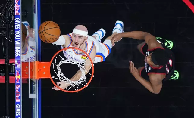 Oklahoma City Thunder's Alex Caruso, left, goes up for a shot against Philadelphia 76ers' Vj Edgecombe during the first half of an NBA basketball game Monday, March 23, 2026, in Philadelphia. (AP Photo/Matt Slocum)