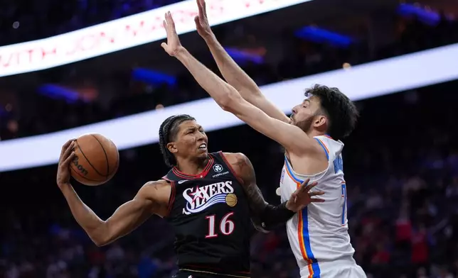 Philadelphia 76ers' Marjon Beauchamp, left, goes up for a shot against Oklahoma City Thunder's Chet Holmgren during the first half of an NBA basketball game Monday, March 23, 2026, in Philadelphia. (AP Photo/Matt Slocum)