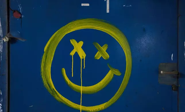 A smiley face is painted on a blue wall beneath Tel Aviv's central bus station, used as a shelter against possible Iranian missile attacks, Thursday, March 12, 2026. (AP Photo/Oded Balilty)