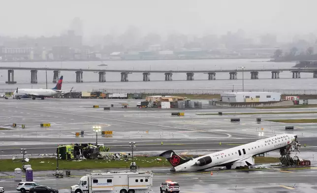 An Air Canada jet and Port Authority fire truck sit on the runway at LaGuardia Airport, Monday, March 23, 2026, after colliding with each other after the jet landed Sunday night in New York. (AP Photo/Seth Wenig)