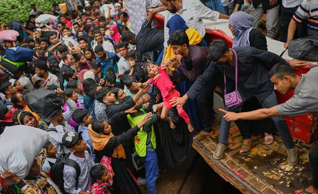 Thousands of travelers scramble and jostle each other to board ferries at the Sadarghat Launch Terminal, joining the massive annual exodus to celebrate Eid al-Fitr in their hometowns, in Dhaka, Bangladesh, Wednesday, March 18, 2026. (AP Photo/Mahmud Hossain Opu)