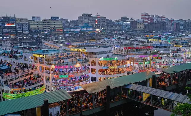 Thousands of travelers scramble to board ferries at the Sadarghat Launch Terminal, joining the massive annual exodus to celebrate Eid al-Fitr in their hometowns, in Dhaka, Bangladesh, Wednesday, March 18, 2026. (AP Photo/Mahmud Hossain Opu)